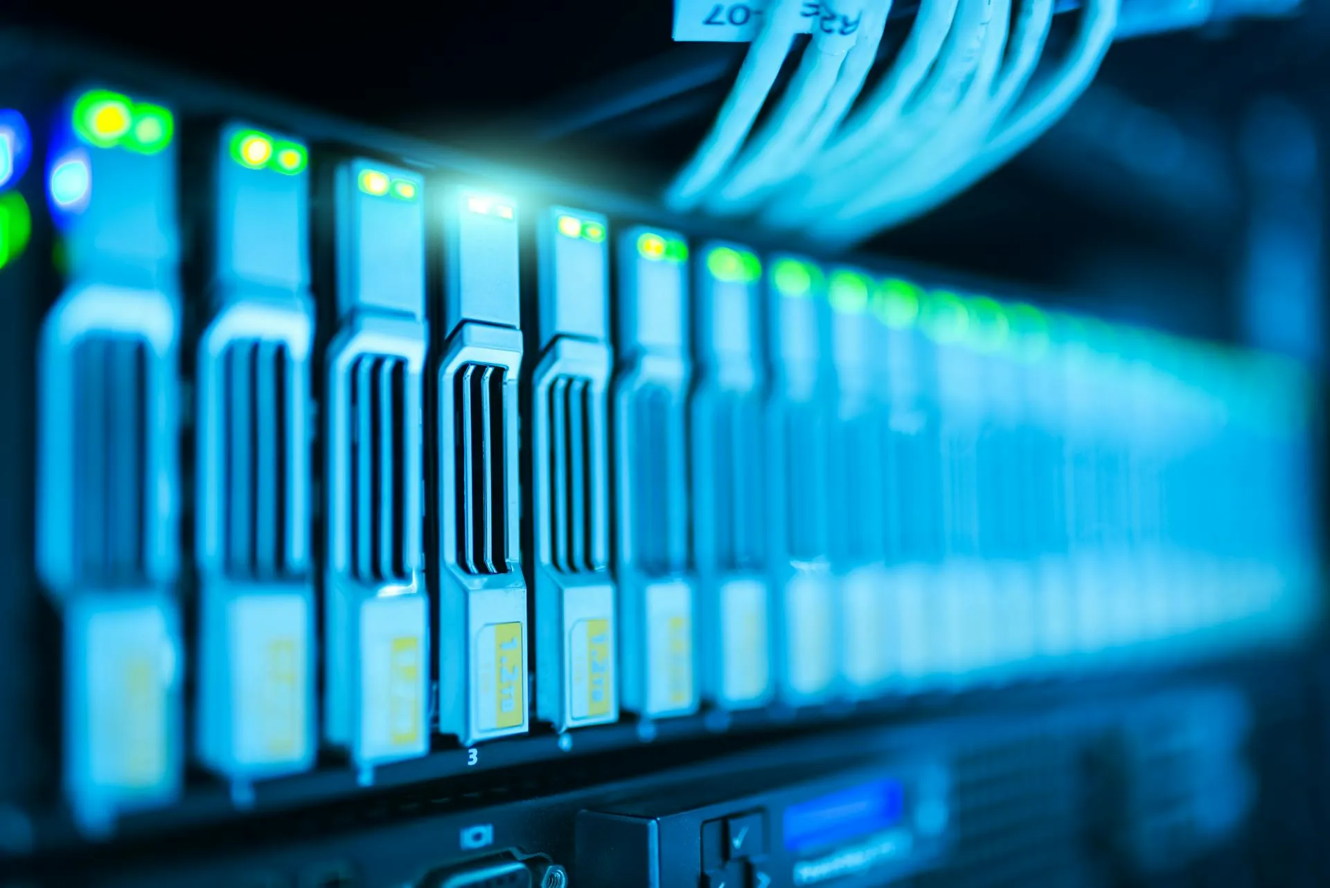 Close detail of a storage array with blue cinematic lighting. Verasor delivers CMMC readiness, GCC High migrations, and Microsoft 365 compliance work for the Defense Industrial Base.